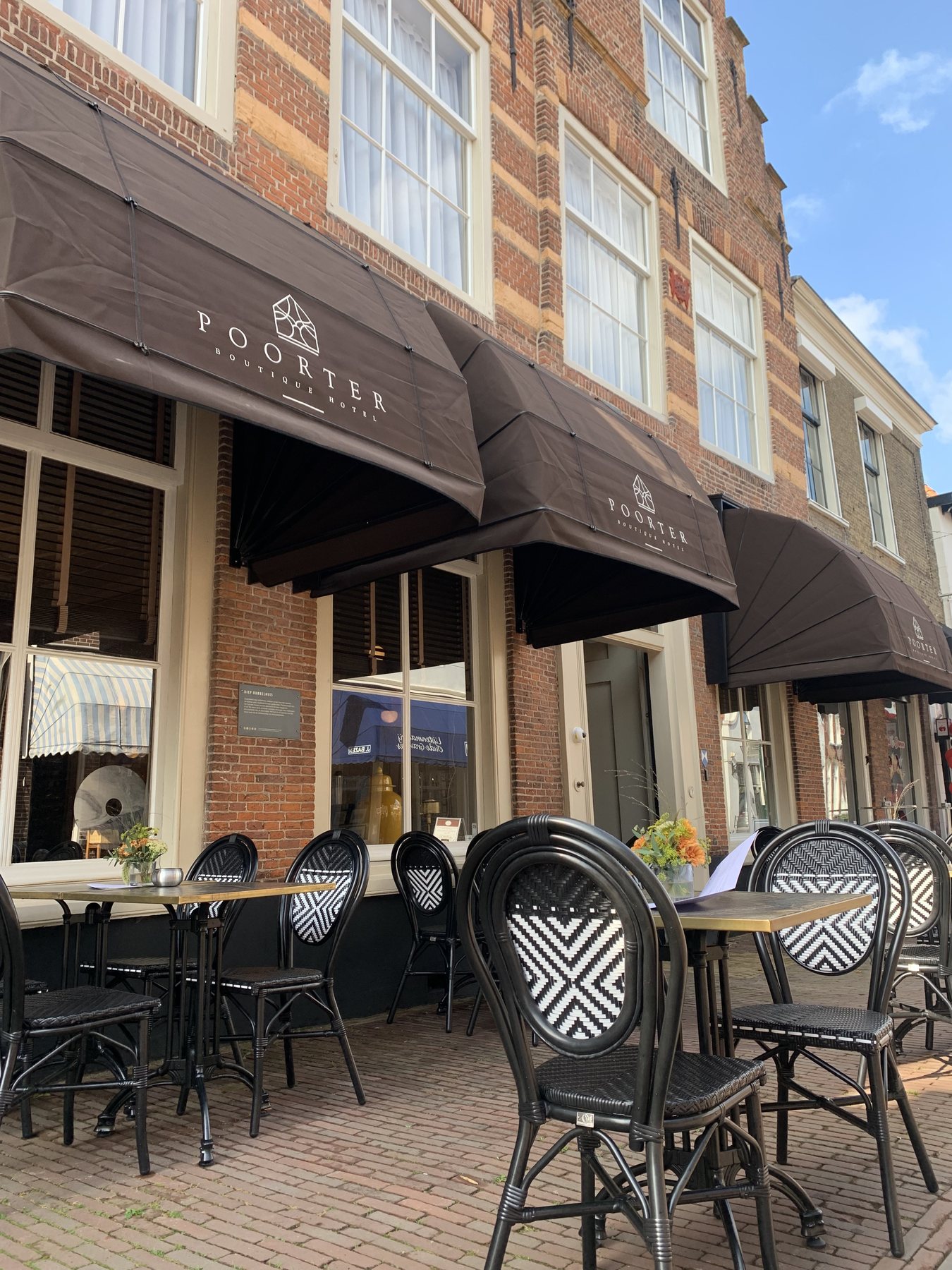 Het terras met luifels en de entree van Poorter Boutique Hotel in Brielle